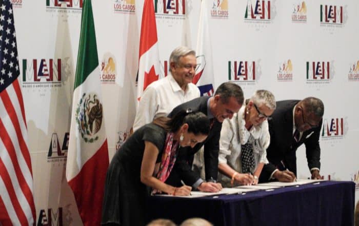 Mexico President AMLO looks on as mayors sign the declaration at the first North America Mayors Summit.